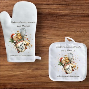 Peut inclure: Ensemble de manique et de dessous de plat blancs avec un motif sur le thème de la pâtisserie. Le motif comprend des biscuits, un fouet et le texte "Baked with Love" et "Cuisiné avec amour par Mamie".