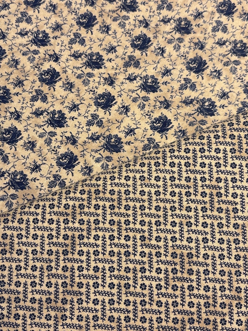 Puede incluir: Dos piezas de tela con diferentes estampados florales azules y crema. Una presenta rosas azules y enredaderas, mientras que la otra tiene un dise&ntilde;o geom&eacute;trico con peque&ntilde;as flores y tallos azules. Adecuado para proyectos de costura o acolchado.