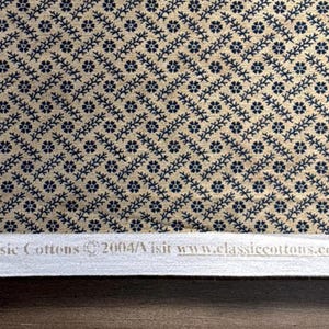 Puede incluir: Primer plano de una tela con un patr&oacute;n repetido de motivos florales y de vid azul marino sobre un fondo beige. La tela tiene un dise&ntilde;o diagonal. El texto "Classic Cottons" y una direcci&oacute;n web son visibles en la parte inferior.