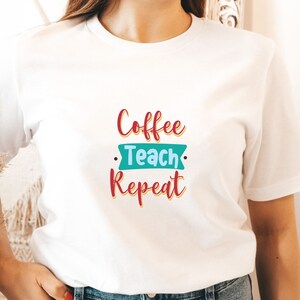 May include: White t-shirt with the text "Coffee Teach Repeat" in red, blue, and yellow lettering.