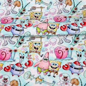 Op de afbeelding: Stof met een herhalend patroon van stripfiguren, waaronder SpongeBob SquarePants, Patrick Star en Octo Tentakel. Het ontwerp bevat zeedieren en bloemmotieven op een lichtblauwe achtergrond.