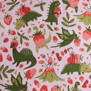 May include: A whimsical pattern featuring green dinosaurs and red strawberries on a light pink background. Some dinosaurs are wearing strawberry hats or holding strawberries. The word "Boom" is also visible.