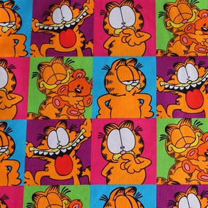 Könnte beinhalten: Ein sich wiederholendes Muster mit der Zeichentrickfigur Garfield in verschiedenen Posen. Die orangefarbene Katze ist vor einem Hintergrund aus farbigen Quadraten in Pink, Grün, Lila und Blau platziert. Einige Quadrate zeigen Garfield mit einem Teddybären.