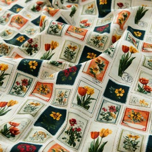 May include: Cream-coloured fabric with a repeating pattern of postage stamp-style squares. Each square showcases a different floral illustration in shades of red, yellow, orange, and green. The fabric has a slightly wrinkled texture, suggesting it is a natural fibre.