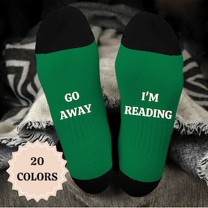 May include: A pair of green socks with black heels. One sock says "GO AWAY" and the other says "I'M READING".