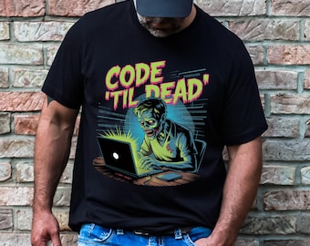 Może przedstawiać: Czarna koszulka z napisem "CODE 'TIL DEAD" w neonowej zieleni i bieli. Grafika przedstawia zombie kodującego na laptopie. Zombie ma na sobie jasnozieloną koszulę i zieloną skórę. Tło ma kod binarny.