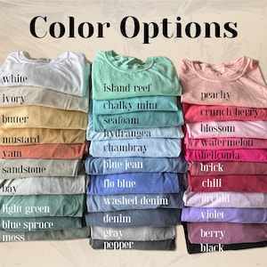 May include: Stacks of t-shirts in various colors, including white, island reef, and peachy. The image displays the text "Color Options" at the top, with a list of color names such as "chalky mint", "blossom", and "berry".
