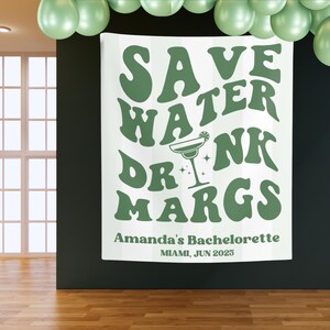 May include: White backdrop with green text that reads "Save Water Drink Margs" in a retro font. Below the text is "Amanda's Bachelorette Miami, Jun 2025".