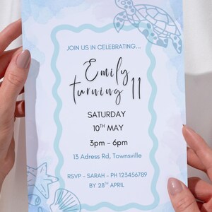 Puede incluir: Una invitación de cumpleaños azul claro con una ilustración de tortuga y detalles en acuarela. La invitación dice "Únete a nosotros para celebrar... Emily cumple 11 años" con la fecha, hora y lugar. También se incluyen los detalles de RSVP.