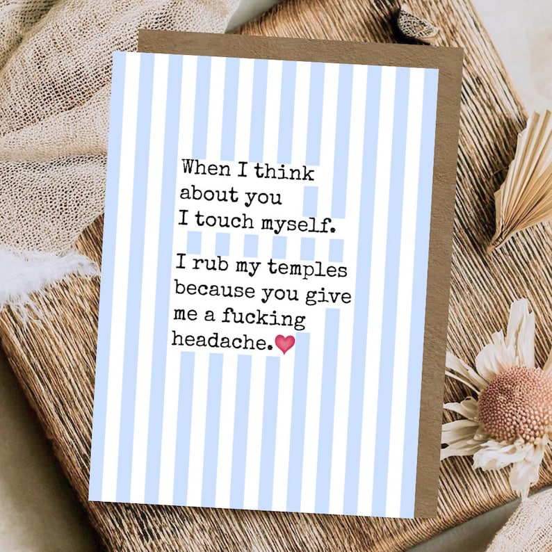 May include: A greeting card with a light blue and white vertical striped pattern. The text reads: When I think about you I touch myself. I rub my temples because you give me a fucking headache. A small pink heart icon follows the text.