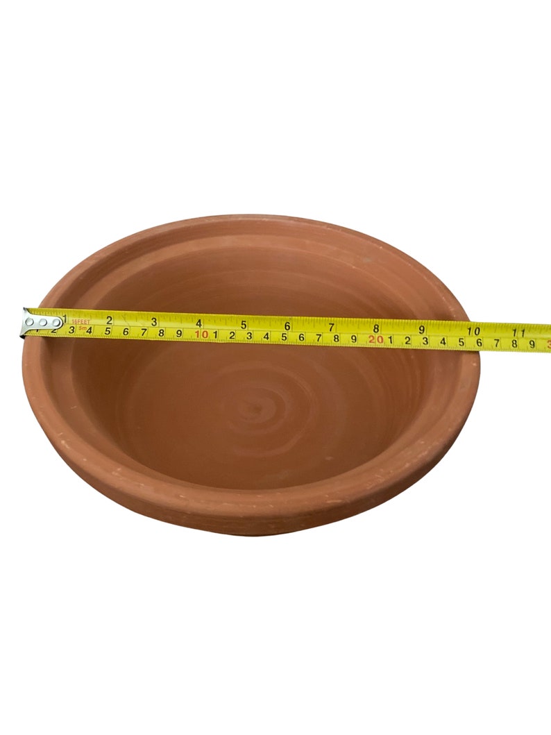 May include: A terracotta bowl with a diameter of 10 inches. The bowl is made of unglazed clay and has a natural brown color.