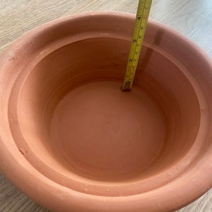 May include: A terracotta flower pot with a diameter of 4 inches. The pot is made of unglazed clay and has a natural, earthy colour.