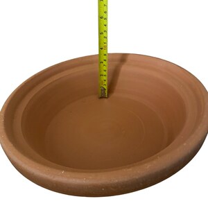 May include: A terracotta clay pot with a diameter of 10 inches. The pot is unglazed and has a natural brown color.