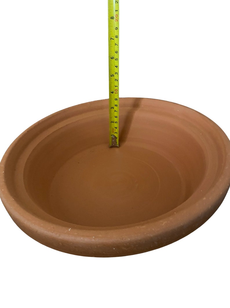 May include: A terracotta clay pot with a diameter of 10 inches. The pot is unglazed and has a natural brown color.
