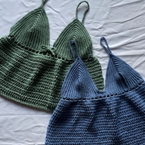 May include: Two crocheted tops, one in a sage green color and one in a light blue color. Both tops have a V-neck and thin straps.
