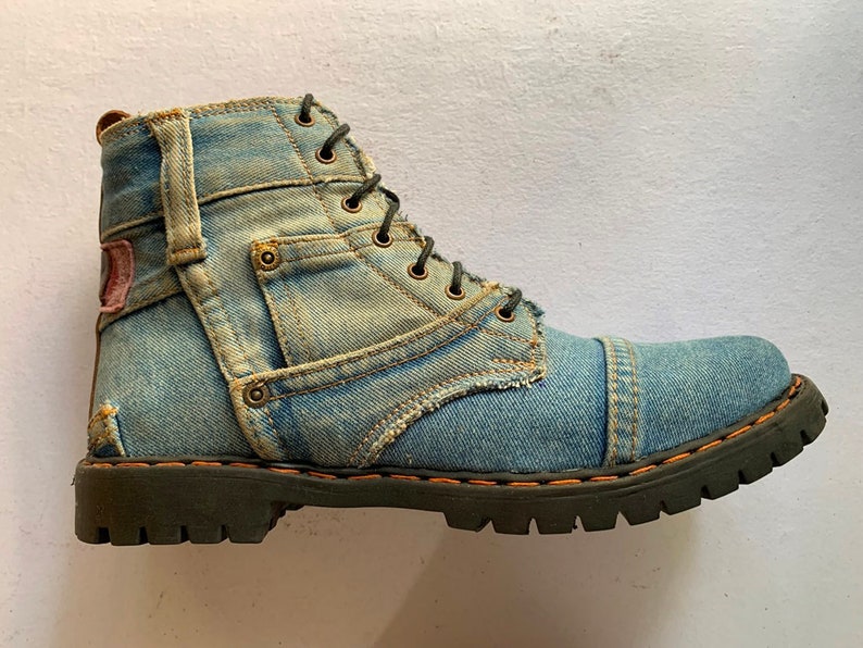 May include: Blue denim boots with a lace-up closure and a black rubber sole.