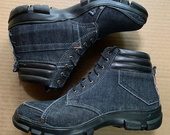May include: A pair of black denim boots with black leather accents and laces. The boots have a rugged outsole.