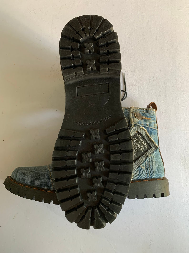 May include: Blue denim boots with black laces and a black rubber sole. The boots have a distressed look and the text "Brave Soul" and "Size 8 Skanders" is visible on the side.