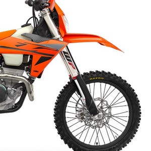 May include: An orange and black dirt bike with a black tyre and silver suspension. The front wheel is in focus, showcasing the tyre tread and brake disc. The bike has a streamlined design.