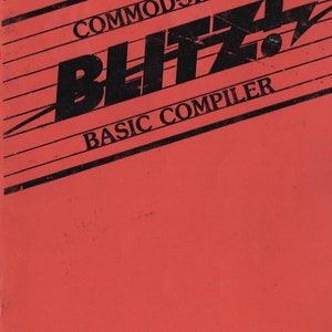 May include: A red cover for a Commodore 128 Blitz Basic Compiler manual. The cover features black text and a black lightning bolt graphic.