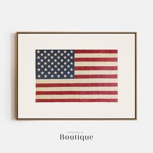 May include: A framed print of a vintage American flag with faded red, white, and blue colors. The flag is slightly worn and has a rustic look.