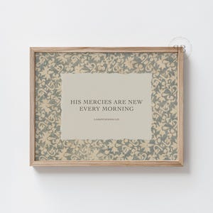 Könnte beinhalten: Gerahmter Druck mit dem Text "HIS MERCIES ARE NEW EVERY MORNING". Der Druck hat einen hellbeigen Hintergrund mit einem floralen Muster in Grau- und Beigetönen. Der Rahmen besteht aus hellem Holz.