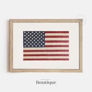 May include: A framed print of a vintage American flag with faded red, white, and blue colors. The flag is displayed in a light wood frame.