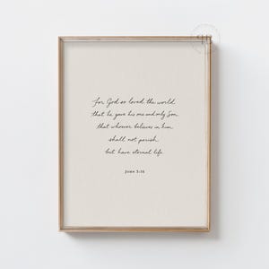 Puede incluir: Una impresión enmarcada con un fondo beige claro y una elegante escritura negra. El texto dice "Porque tanto amó Dios al mundo..." seguido de Juan 3:16. El marco es de color marrón claro y cálido, añadiendo un toque clásico.