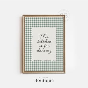 Może przedstawiać: Oprawiona grafika ścienna ze złotą ramą. Grafika przedstawia zielono-biały wzór w kratę i teksturowany papier z napisem "This kitchen is for dancing" czarnym pismem. Słowo "Boutique" znajduje się na dole.