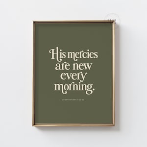 Puede incluir: Un cuadro decorativo enmarcado con fondo verde oliva oscuro y el texto en color crema 'His mercies are new every morning.' junto a la cita más pequeña 'LAMENTATIONS 3:22-23' centrada debajo en una tipografía con serifa.