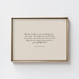 Peut inclure: Une impression encadrée avec un cadre doré. L'impression a un fond beige avec du texte noir en cursive qui dit : « Mais je veux rappeler ceci à mon cœur, et c'est pourquoi j'ai de l'espoir... grande est ta fidélité. » Le texte est de Lamentations 3:21-23.