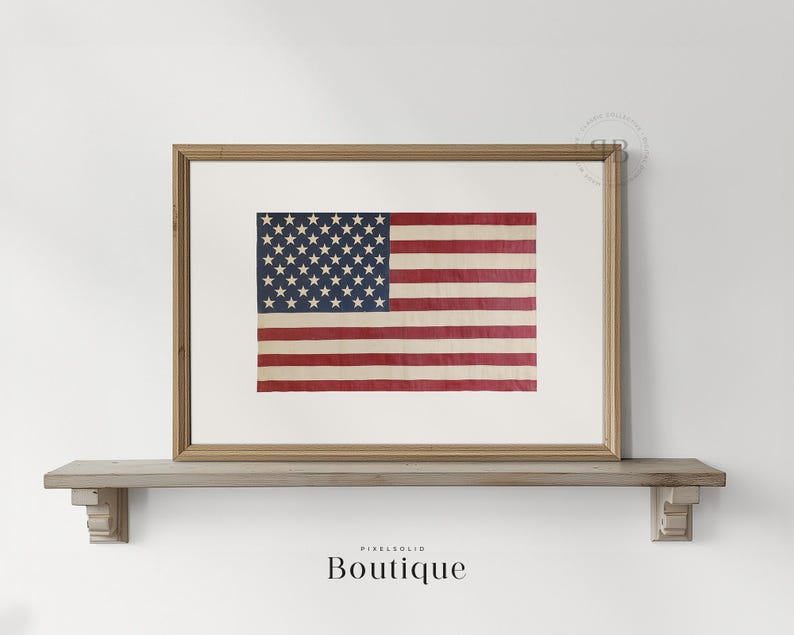 May include: A framed print of an old, faded American flag with red, white, and blue stripes and white stars on a blue field. The flag is displayed on a wooden shelf.