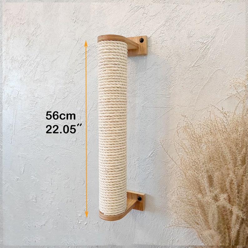 May include: A natural sisal rope cat scratching post mounted on a wooden wall bracket. The post is 56cm tall and is made of natural sisal rope wrapped around a wooden core. The post is mounted on a wooden wall bracket with a natural wood finish.