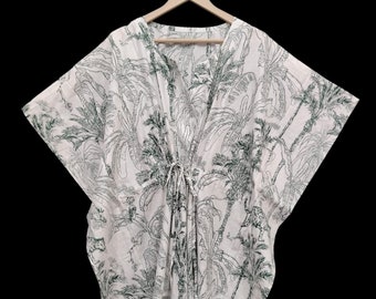Peut inclure: Kaftan blanc avec un imprimé de palmiers verts. Le kaftan a un col en V et une cravate à la taille.