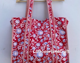 May include: Red and white quilted tote bag with a floral print. The bag has a long strap and the text "CottonartandCraft" is printed on the front.