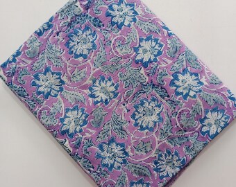 May include: Purple fabric with a blue and white floral print. The fabric has a soft, textured feel and is perfect for crafting projects.