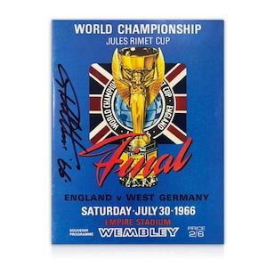 Peut inclure: Un programme souvenir bleu pour la finale de la Coupe du Monde 1966, avec la Coupe Jules Rimet. Le programme comprend les détails du match Angleterre contre Allemagne de l'Ouest, la date et le stade. La couverture présente une illustration de trophée doré et du texte.