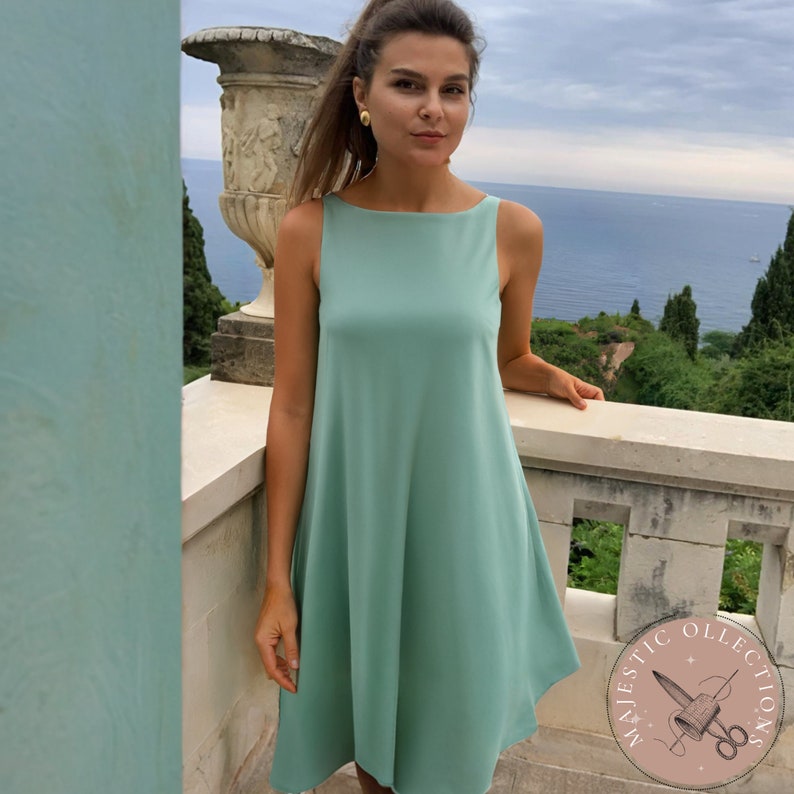 Puede incluir: Un vestido sin mangas, de color verde claro, de corte A con cuello barco. El vestido es de largo hasta la rodilla y tiene un dise&ntilde;o simple y elegante.