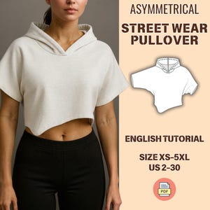 Puede incluir: Jersey asimétrico de estilo urbano en color crema, con capucha y mangas cortas. El diseño presenta una longitud recortada y un dobladillo en ángulo único. La imagen incluye el texto "ASYMMETRICAL STREET WEAR PULLOVER" y "ENGLISH TUTORIAL".