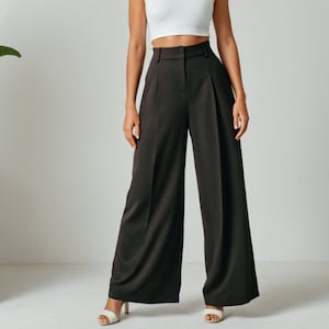Op de afbeelding: Een wijde, donkerbruine broek met een hoge taille en plooien. De broek is gemaakt van een gladde, zijdeachtige stof.