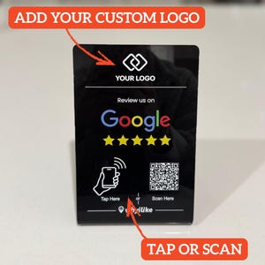 May include: A black rectangular sign with the text "ADD YOUR CUSTOM LOGO" at the top. The sign features a logo, the words "Review us on Google" with five gold stars, and instructions to "Tap Here" or "Scan Here" with a QR code.