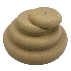 Könnte beinhalten: Ein Stapel aus vier unfertigen Holzscheiben unterschiedlicher Größe. Der größte Kreis befindet sich unten, wobei jeder Kreis darüber kleiner wird. Auf dem obersten Kreis ist eine kleine Metallschraube zu sehen. Das Holz hat eine hellbraune Farbe.