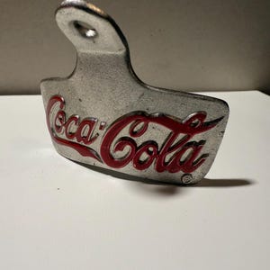 Questo è un apribottiglie da parete Coca-Cola di TableCraft