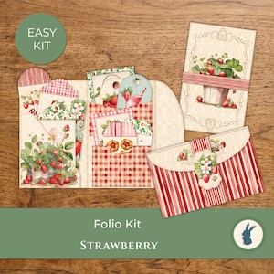 Pode incluir: Um kit de fólio de papel com tema de morango, incluindo um organizador de cartolina dobrável com bolsos, um cartão retangular com uma ilustração de um morangueiro e um envelope às riscas. O conjunto inclui padrões de xadrez vichy vermelho e branco.