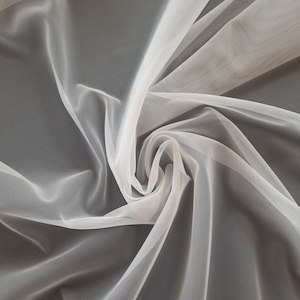 May include: White sheer fabric with a delicate, fine mesh texture. The fabric is draped and folded, creating soft, flowing lines.