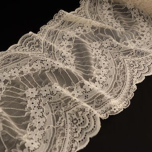 Puede incluir: Borde de encaje blanco con borde festoneado y patrón floral.