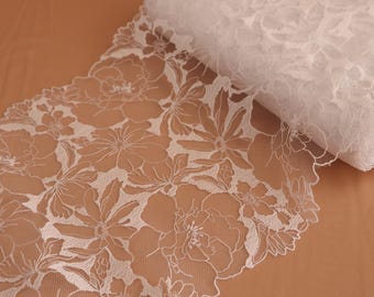 May include: White floral lace trim with a delicate pattern. The lace is soft and sheer, with a scalloped edge.