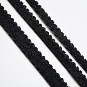 May include: Three black elastic bands with a scalloped edge.