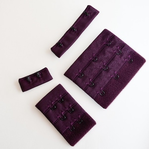 Puede incluir: Cuatro extensores de tirantes de sujetador de color morado con ganchos y ojales de metal negro. Los extensores son de diferentes tamaños.