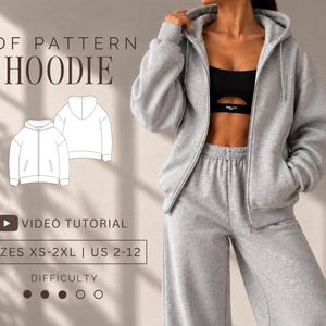 Puede incluir: Una sudadera gris con cremallera y pantalones de chándal a juego. La imagen incluye el texto PDF PATTERN HOODIE, VIDEO TUTORIAL, SIZES XS-2XL | US 2-12 y DIFFICULTY con tres círculos rellenos. Un dibujo lineal blanco muestra la sudadera.